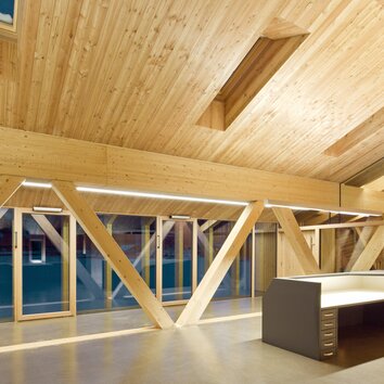 Dachgeschoss mit Holzvertäfelung und großen Fenstern