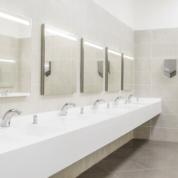öffentlicher Nassraum mit vier Spiegeln und vier Waschbecken