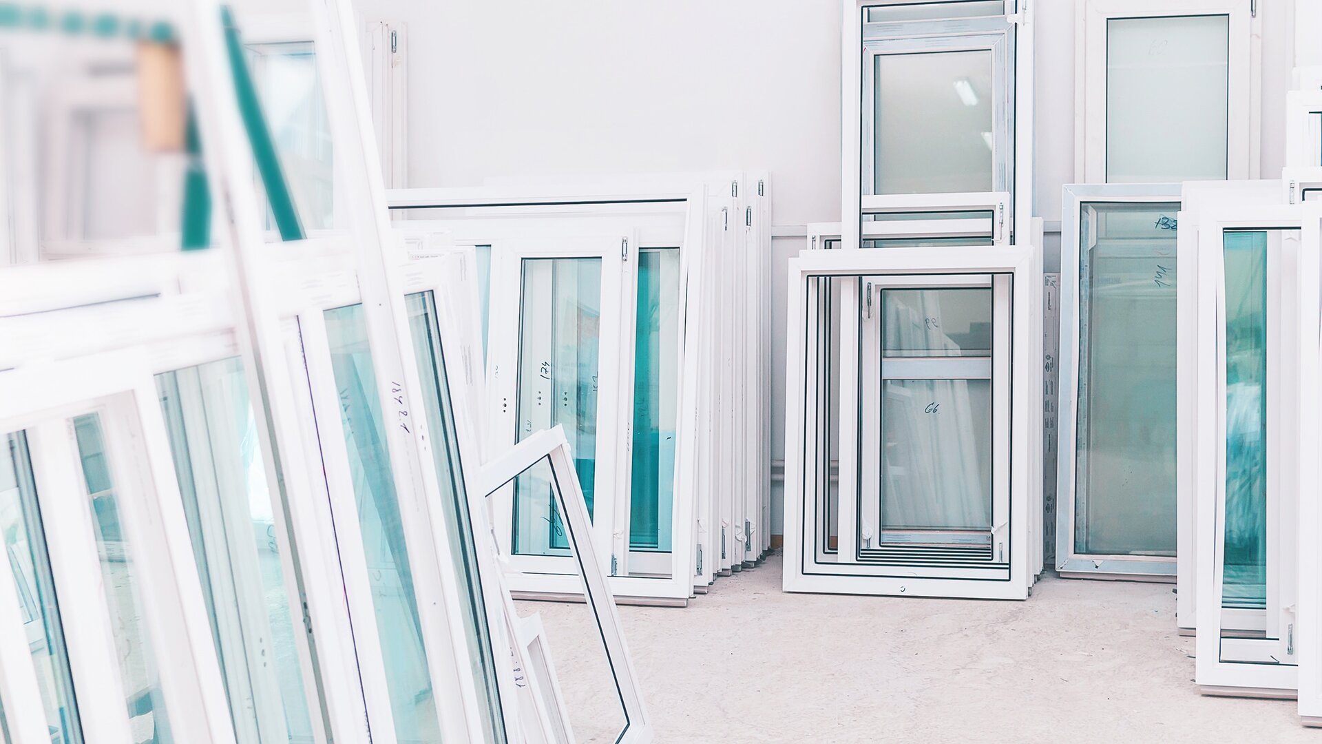 Bright storage room with concrete floor and numerous white windows with bluish glass.