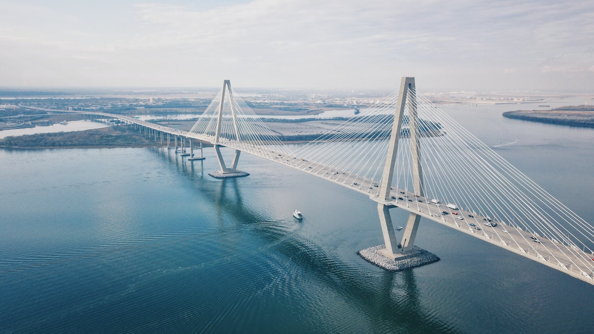 Moderne lange brug over zee met ruitvormige brugpijlers en kabels.