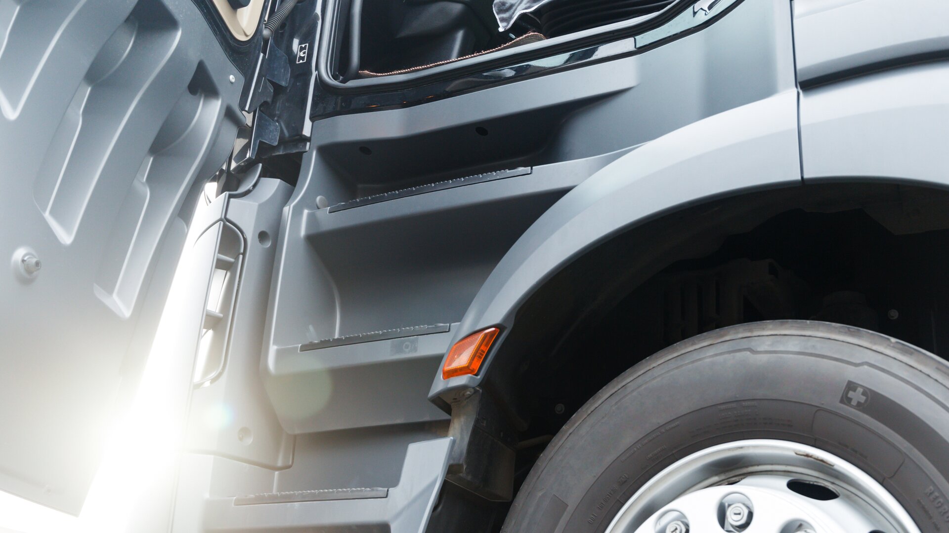 Close-up van de carrosserie van een vrachtwagen met open bestuurdersportier.
