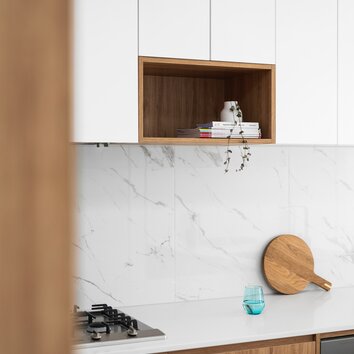 Aufnahme einer Küche mit weißer Arbeitsplatte und Holzdetails. 
